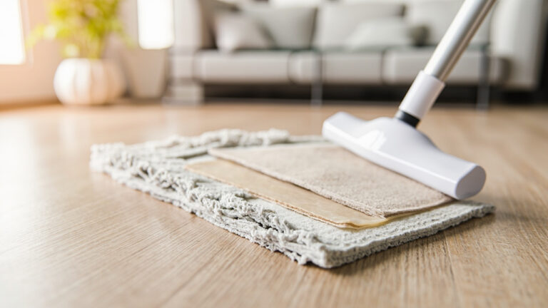 "Microfiber mop cleaning SPC vinyl plank flooring with pH-neutral cleaner in modern living room"