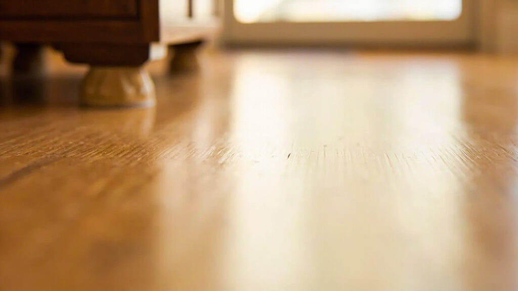 "Hardwood floor with furniture leg equipped with felt floor protector pad to prevent scratches"