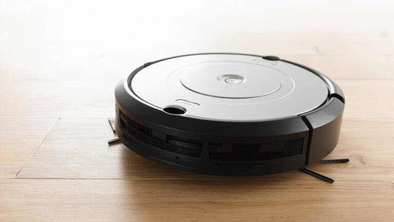 "Roomba 600 series robot vacuum top-down view showing extractors and side brush"