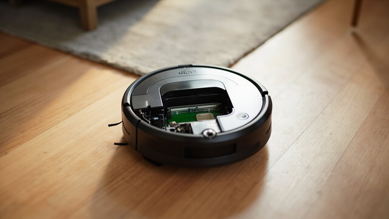 iRobot Roomba i7 robot vacuum with open dust bin compartment on hardwood floor